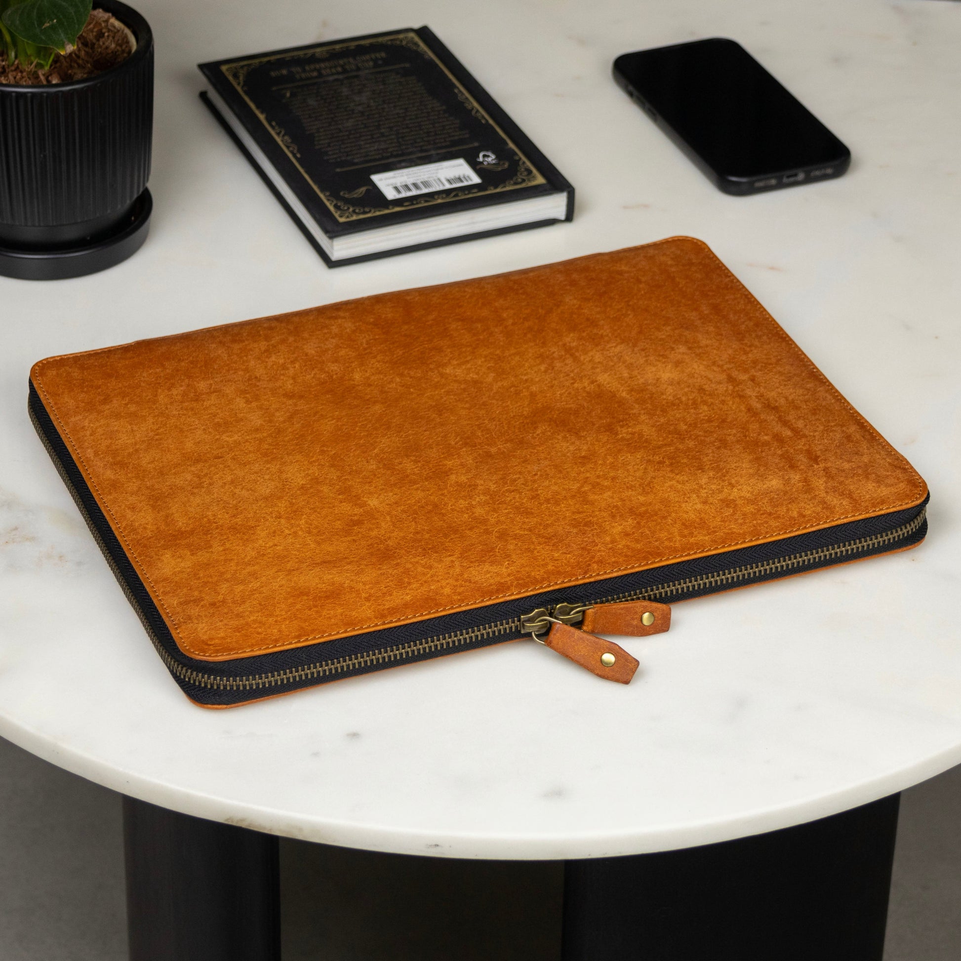 Crafted from vegetable-tanned leather, this zip-around laptop case is designed to carry your MacBook, documents, and tech essentials—all in one sleek, organized folio