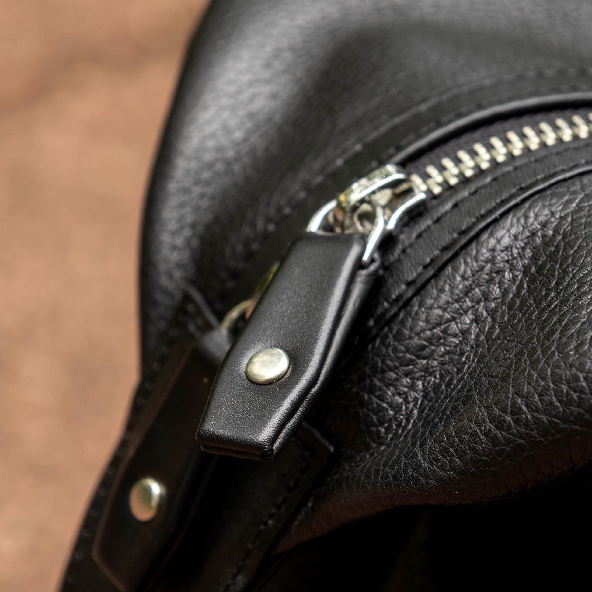 YKK Zippers with pull tabs of leather fastened with solid brass rivets.