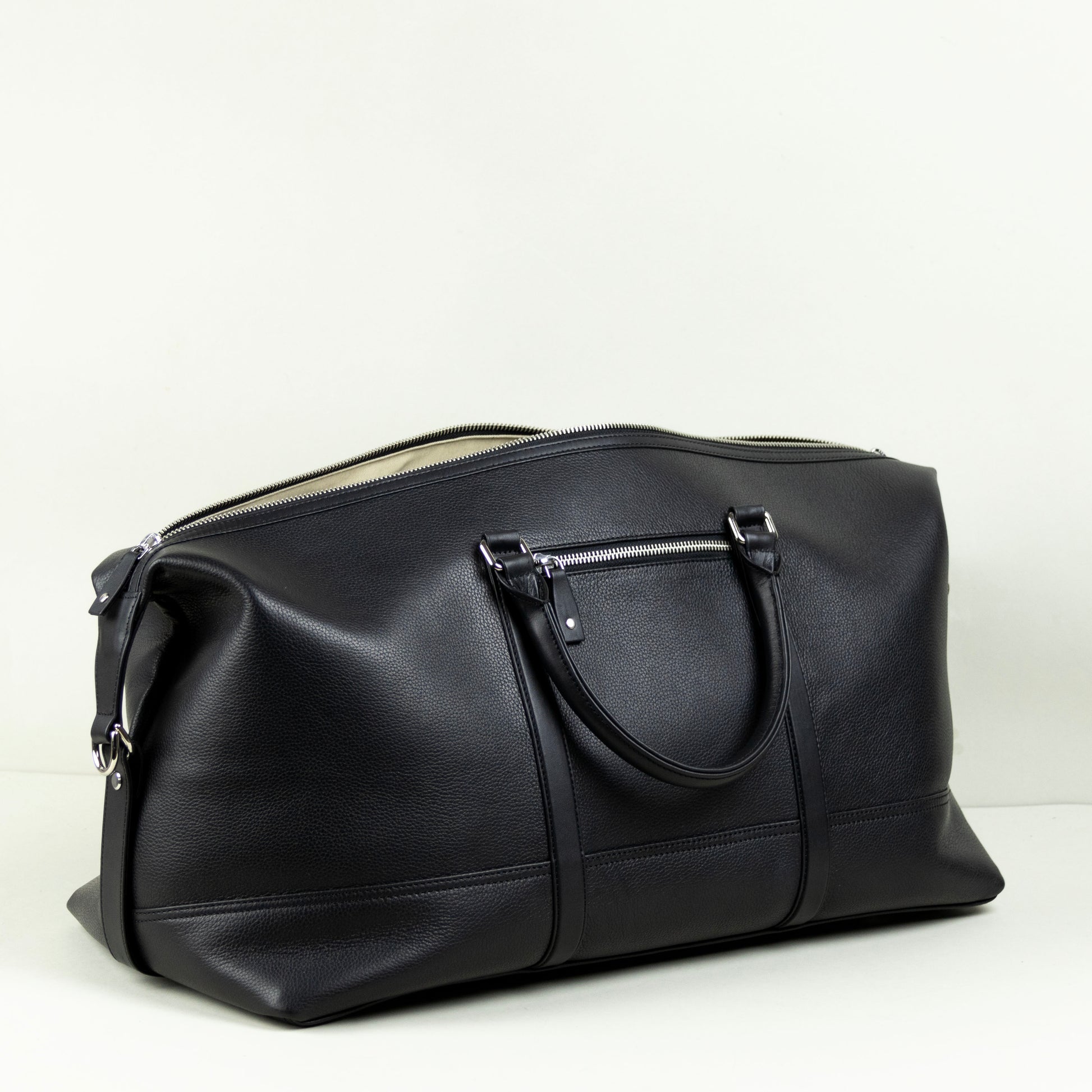 Black leather duffel bag on a light gray background