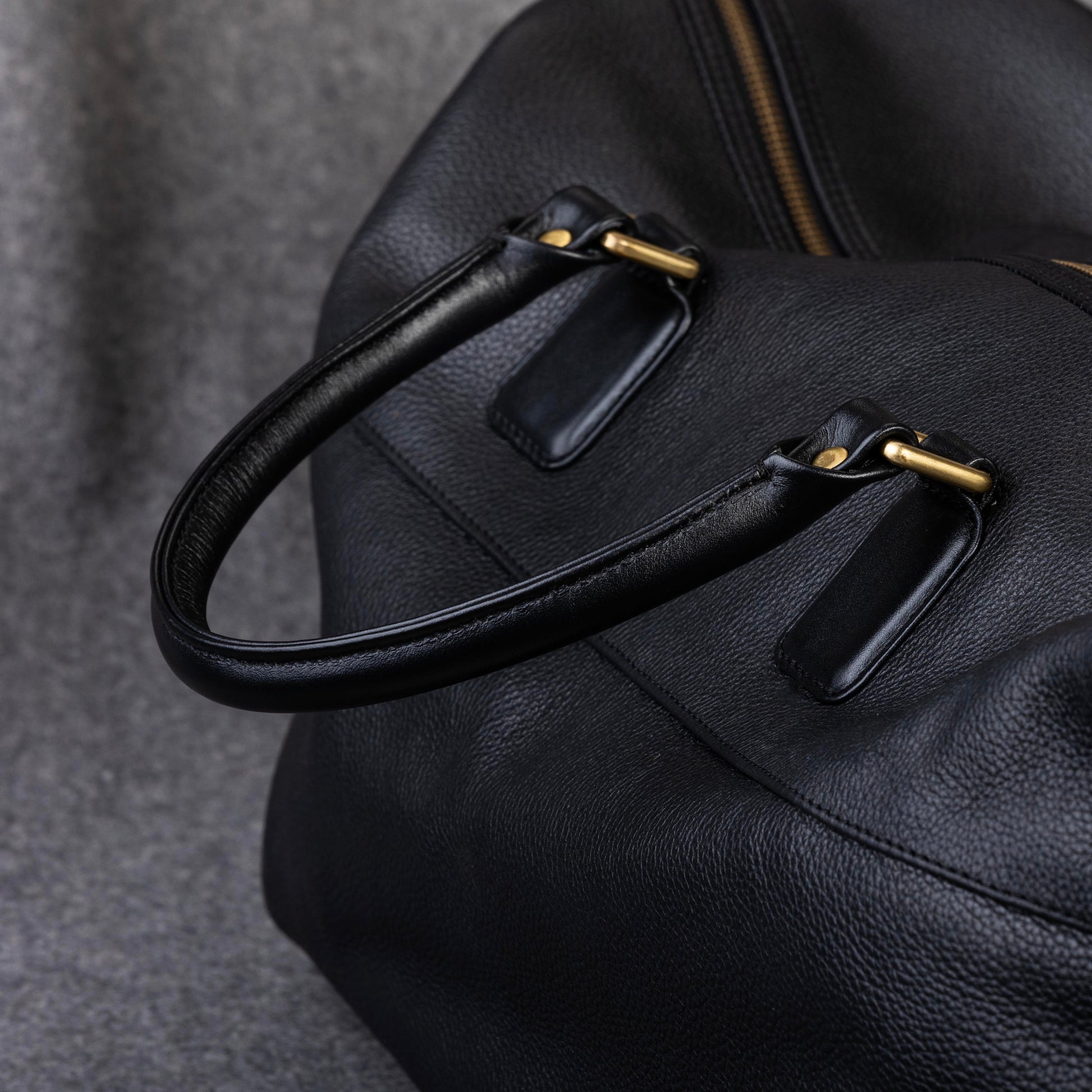 The Leather Duffle Bag has Tubular Handles for hand carry