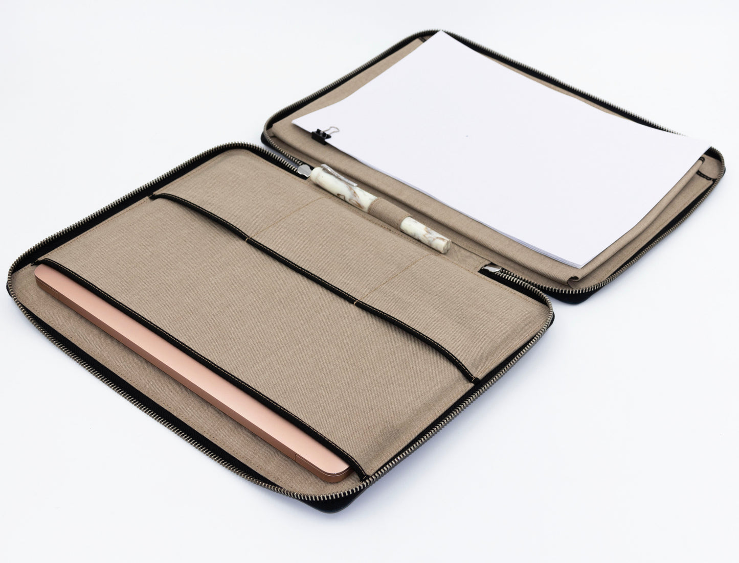 The interior of the case unzips to lay completely flat on a table. The left features a compartment to hold laptop, and the right side features a compartment to carry documents. Small flat pockets for carrying passport or pocket notebook