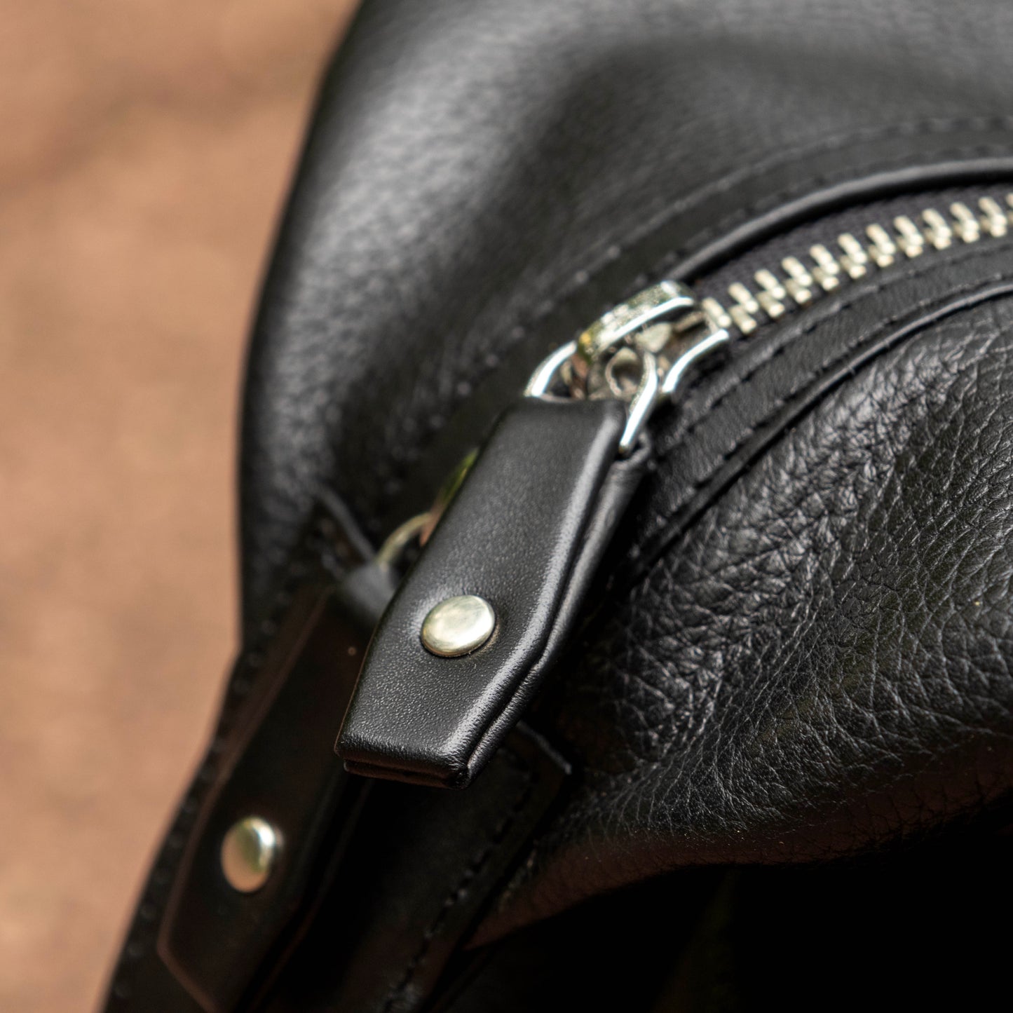 YKK Zippers with pull tabs of leather fastened with solid brass rivets. 